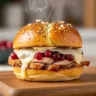 Close up of cheesy cranberry turkey sliders with poppy seed glaze