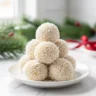 Close-up of pineapple christmas balls stacked on a plate with coconut coating