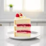 Close up of a slice of ultimate raspberry layer cake with white chocolate buttercream
