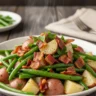 Close-up of slow cooker ranch green beans and potatoes topped with crispy turkey turkey turkey bacon