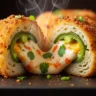 Macro close-up of a golden, crispy baked jalapeño popper stuffed onion ring cut in half, revealing the creamy, spicy cheese filling and tender onion.