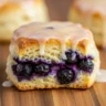 Macro close-up of a flaky blueberry biscuit with shimmering vanilla glaze