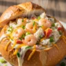 Macro close-up of a steaming Luxe Creamy Seafood Bread Bowl Delight, overflowing with cheesy shrimp and crab, garnished with fresh parsley.