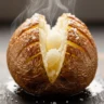 Macro close-up of a perfectly air fryer crispy baked potato, steam rising, golden crunchy skin and fluffy interior.