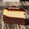 Macro close-up of a slice of Decadent Double-Layer Dream Brownie Cheesecake with fudgy brownie, creamy cheesecake, and glossy ganache.
