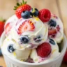 Macro close-up of creamy homemade Velvet Swirl No-Churn Frozen Greek Yogurt with fresh berry swirls and lemon zest in a bowl.