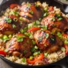 Close-up of Effortless Sticky Honey BBQ Chicken & Rice Skillet in a cast iron pan, garnished with fresh parsley.