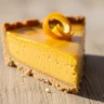 Close-up of a slice of Zesty Orange Dream Tart with a golden crust and vibrant orange filling