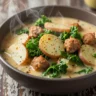 Macro close-up of creamy Zuppa Toscana with turkey sausage and kale in a rustic bowl
