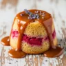 Macro close-up of a Whimsical Sticky Rhubarb Lavender Butterbeer Pudding Bake, drenched in caramel sauce and garnished with lavender.