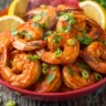 Macro close-up of Explosive Zesty Cajun Voodoo Shrimp, rich red sauce, fresh parsley and lemon wedges