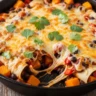 Close-up of bubbling One-Pan Butternut and Black Bean Enchilada Skillet with melted cheese and fresh cilantro