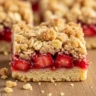 Golden Harvest Strawberry Oatmeal Crumble Bars with juicy strawberry filling and golden oat streusel topping.